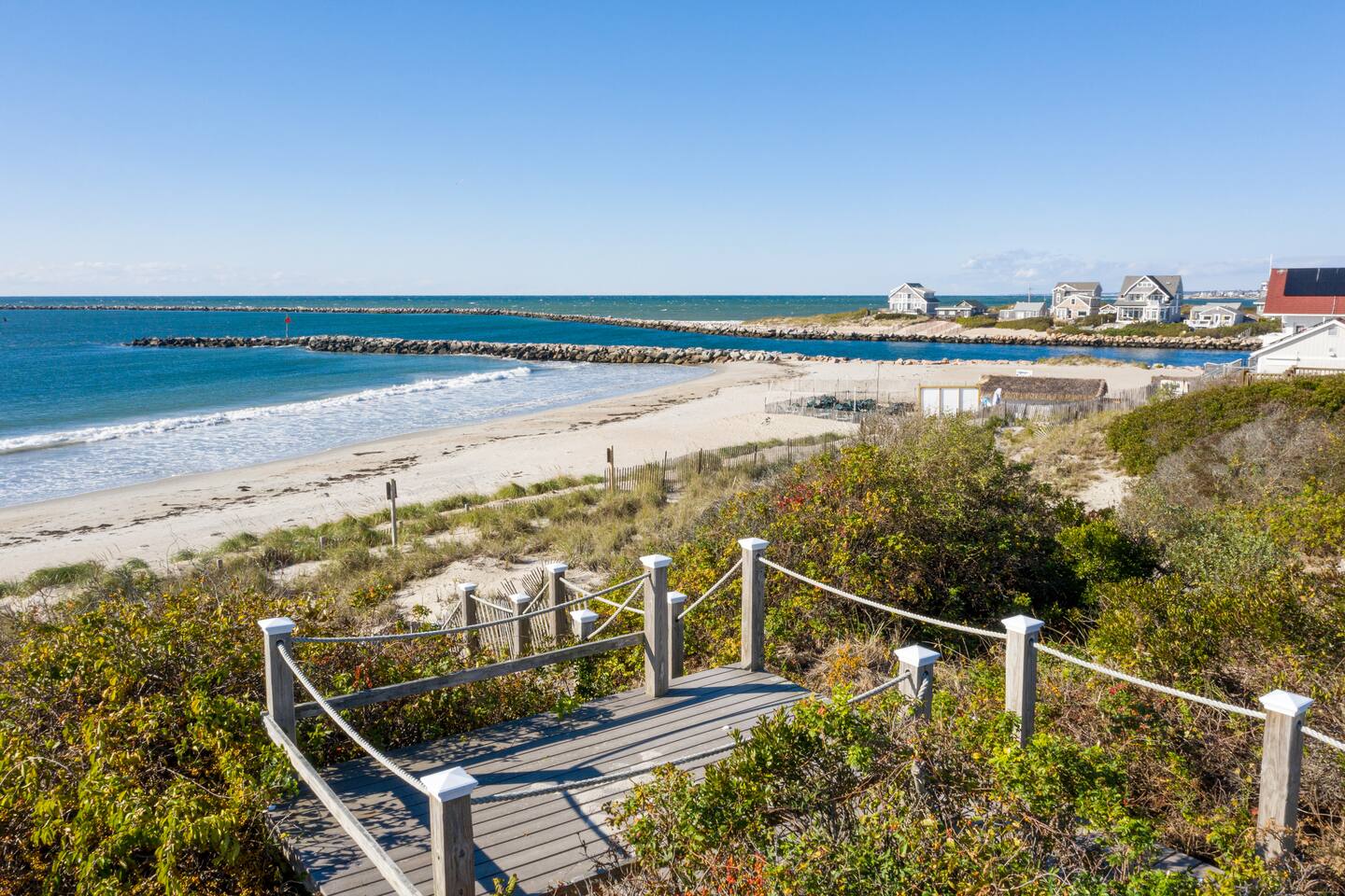 The beach and Point Judith breakwater at Sand Hill Cove in Narragansett, Rhode Island, from the boardwalk path of a Loyal Companions vacation rental
